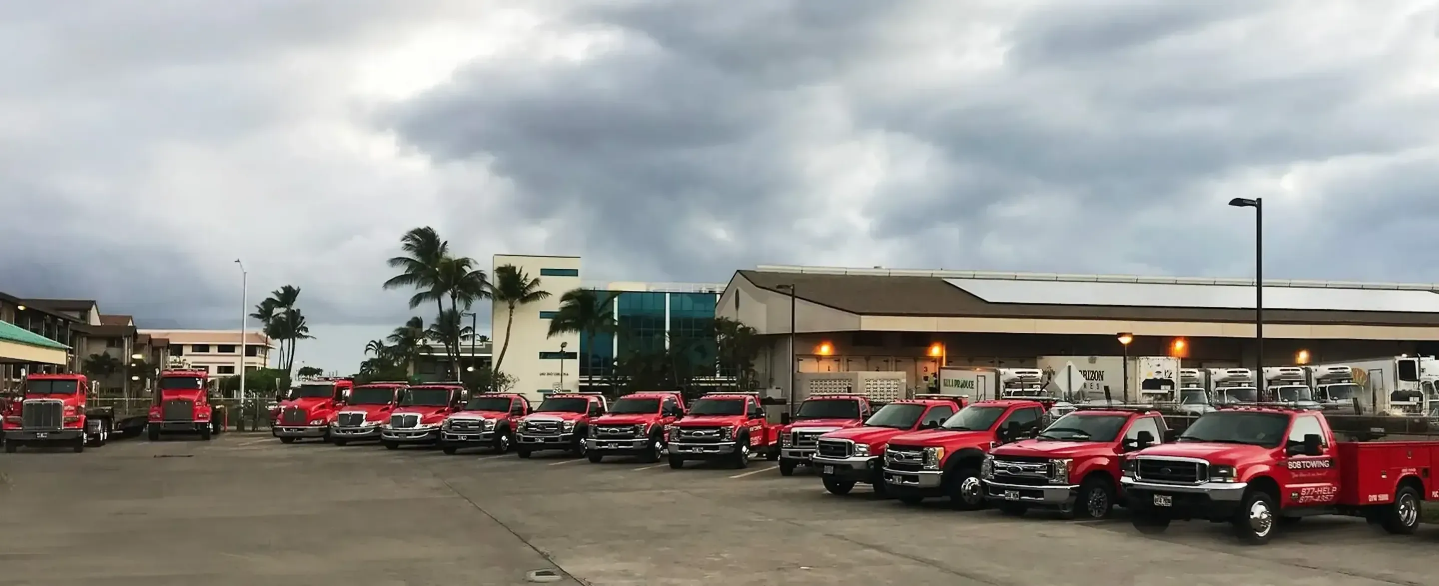 808 Towing fleet of red tow trucks at the Kahului base yard